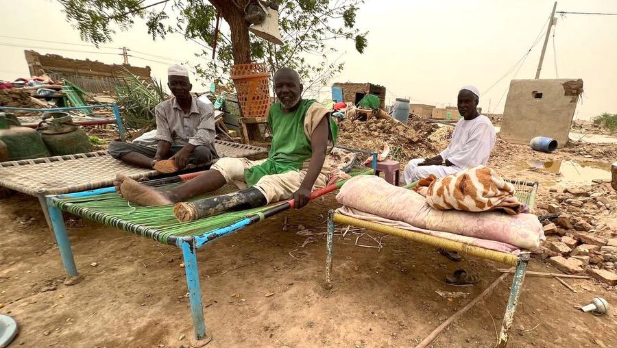 Warga beraktivitas usai banjir akibat hujan lebat yang melanda pemukiman mereka di Sudan, Sabtu (13/8/2022). Akibat banjir tersebut banyak rumah rusak dan menyebabkan korban tewas. (Photo by Sami Alopap/Anadolu Agency via Getty Images)