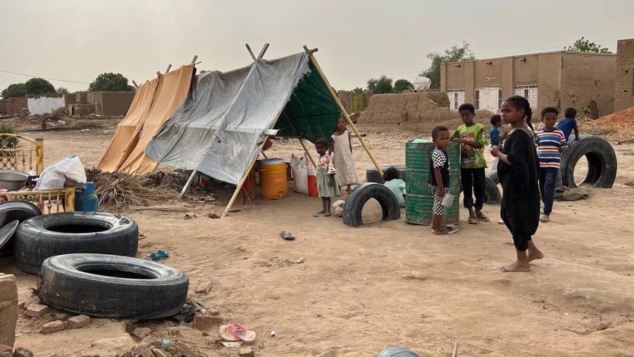 Warga beraktivitas usai banjir akibat hujan lebat yang melanda pemukiman mereka di Sudan, Sabtu (13/8/2022). Akibat banjir tersebut banyak rumah rusak dan menyebabkan korban tewas. (Photo by Sami Alopap/Anadolu Agency via Getty Images)