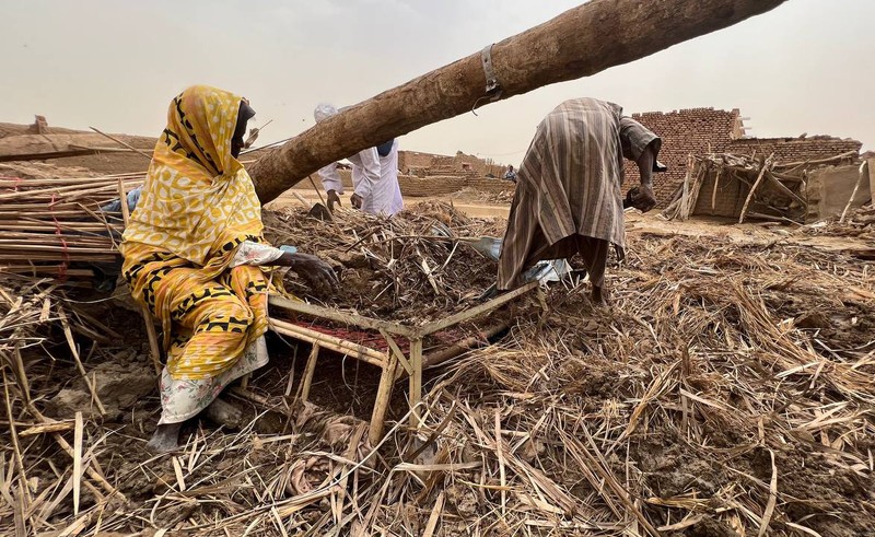 Warga beraktivitas usai banjir akibat hujan lebat yang melanda pemukiman mereka di Sudan, Sabtu (13/8/2022). Akibat banjir tersebut banyak rumah rusak dan menyebabkan korban tewas. (Photo by Sami Alopap/Anadolu Agency via Getty Images)
