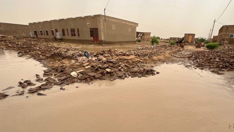 Warga beraktivitas usai banjir akibat hujan lebat yang melanda pemukiman mereka di Sudan, Sabtu (13/8/2022). Akibat banjir tersebut banyak rumah rusak dan menyebabkan korban tewas. (Photo by Sami Alopap/Anadolu Agency via Getty Images)