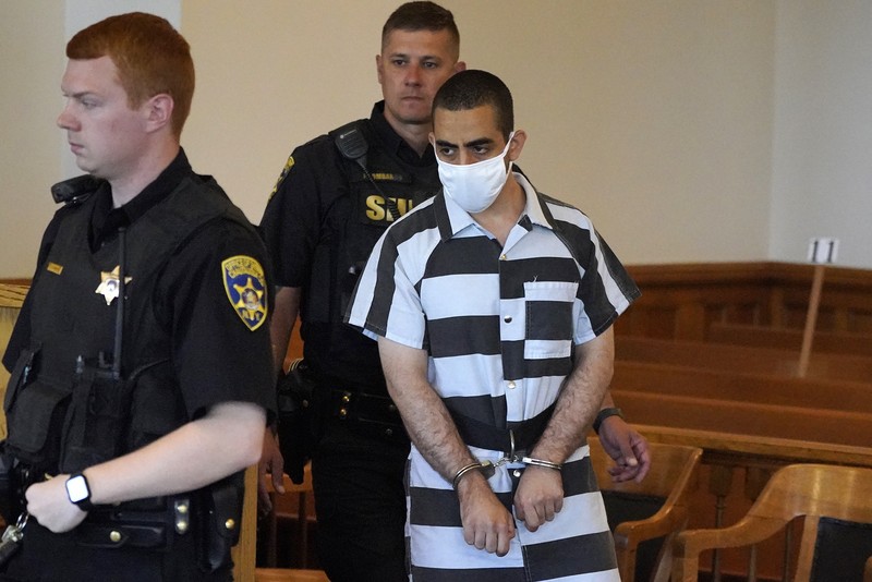 Hadi Matar (24) tengah, tiba untuk dakwaan di Gedung Pengadilan Chautauqua County di Mayville, NY, Sabtu (13/8/2022).. Matar, yang dituduh melakukan serangan penikaman terhadap penulis “Satanic Verses” Salman Rushdie telah masuk pembelaan tidak bersalah di pengadilan New York atas tuduhan percobaan pembunuhan dan penyerangan. (AP Photo/Gene J. Puskar)