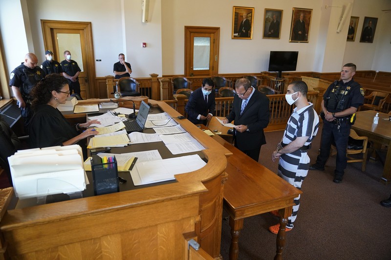 Penusuk Salman Rushdie, Hadi Matar Hadi Matar (24) tengah, tiba untuk dakwaan di Gedung Pengadilan Chautauqua County di Mayville, NY, Sabtu (13/8/2022).. Matar, yang dituduh melakukan serangan penikaman terhadap penulis “Satanic Verses” Salman Rushdie telah masuk pembelaan tidak bersalah di pengadilan New York atas tuduhan percobaan pembunuhan dan penyerangan. (AP Photo/Gene J. Puskar)