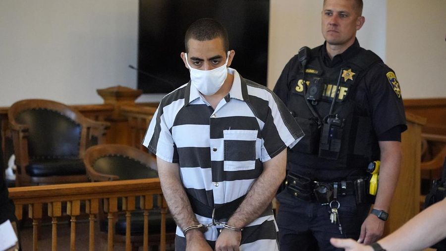 Hadi Matar (24) tengah, tiba untuk dakwaan di Gedung Pengadilan Chautauqua County di Mayville, NY, Sabtu (13/8/2022).. Matar, yang dituduh melakukan serangan penikaman terhadap penulis “Satanic Verses” Salman Rushdie telah masuk pembelaan tidak bersalah di pengadilan New York atas tuduhan percobaan pembunuhan dan penyerangan. (AP Photo/Gene J. Puskar)
