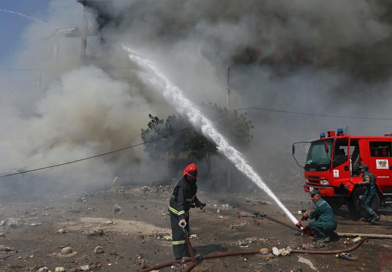 Petugas pemadam kebakaran memadamkan api setelah terjadi ledakan pada gudang kembang api di sebuah pusat perbelanjaan di Yerevan, Armenia, MInggu (14/8/2022). (Vahram Baghdasaryan/Photolure via REUTERS)