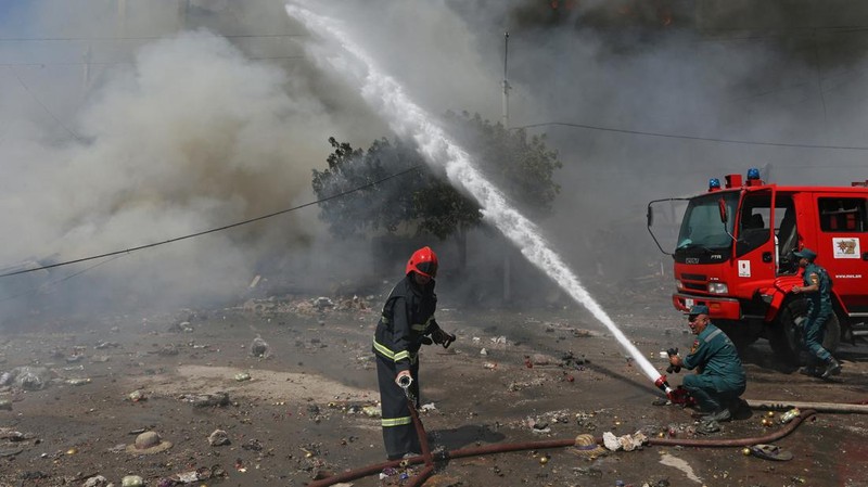 Petugas pemadam kebakaran memadamkan api setelah terjadi ledakan pada gudang kembang api di sebuah pusat perbelanjaan di Yerevan, Armenia, MInggu (14/8/2022). (Vahram Baghdasaryan/Photolure via REUTERS)