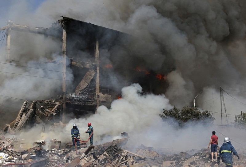 Petugas pemadam kebakaran memadamkan api setelah terjadi ledakan pada gudang kembang api di sebuah pusat perbelanjaan di Yerevan, Armenia, MInggu (14/8/2022). (Vahram Baghdasaryan/Photolure via REUTERS)