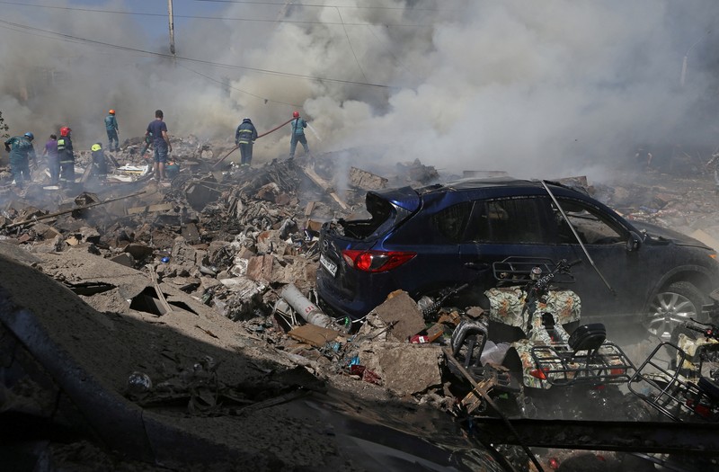 Petugas pemadam kebakaran memadamkan api setelah terjadi ledakan pada gudang kembang api di sebuah pusat perbelanjaan di Yerevan, Armenia, MInggu (14/8/2022). (Vahram Baghdasaryan/Photolure via REUTERS)