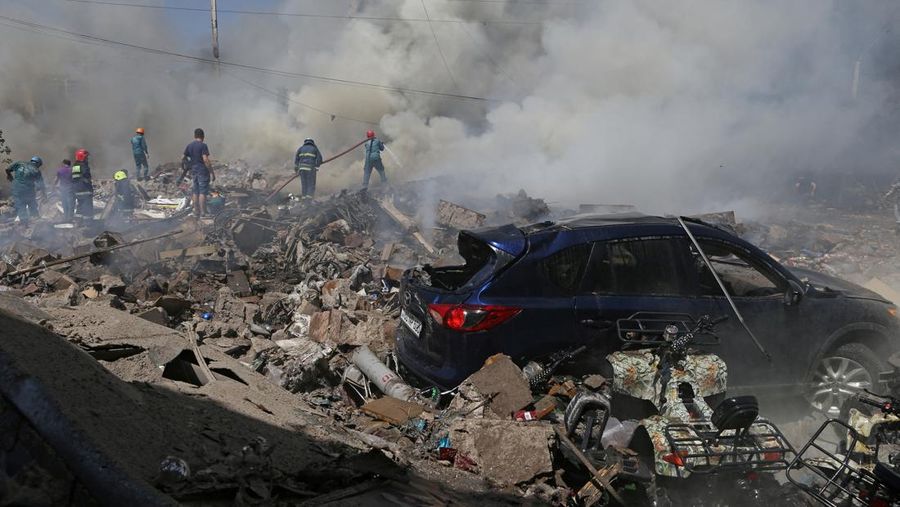 Petugas pemadam kebakaran memadamkan api setelah terjadi ledakan pada gudang kembang api di sebuah pusat perbelanjaan di Yerevan, Armenia, MInggu (14/8/2022). (Vahram Baghdasaryan/Photolure via REUTERS)