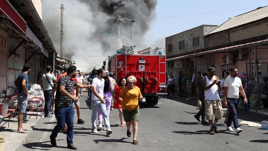 Petugas pemadam kebakaran memadamkan api setelah terjadi ledakan pada gudang kembang api di sebuah pusat perbelanjaan di Yerevan, Armenia, MInggu (14/8/2022). (Vahram Baghdasaryan/Photolure via REUTERS)