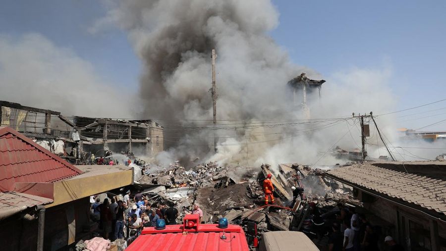 Petugas pemadam kebakaran memadamkan api setelah terjadi ledakan pada gudang kembang api di sebuah pusat perbelanjaan di Yerevan, Armenia, MInggu (14/8/2022). (Vahram Baghdasaryan/Photolure via REUTERS)