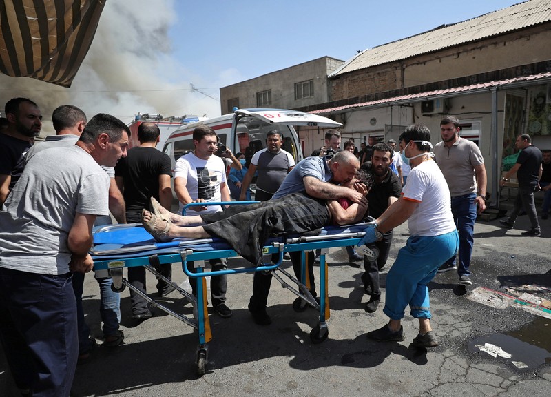 Petugas pemadam kebakaran memadamkan api setelah terjadi ledakan pada gudang kembang api di sebuah pusat perbelanjaan di Yerevan, Armenia, MInggu (14/8/2022). (Vahram Baghdasaryan/Photolure via REUTERS)