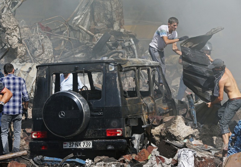 Petugas pemadam kebakaran memadamkan api setelah terjadi ledakan pada gudang kembang api di sebuah pusat perbelanjaan di Yerevan, Armenia, MInggu (14/8/2022). (Vahram Baghdasaryan/Photolure via REUTERS)