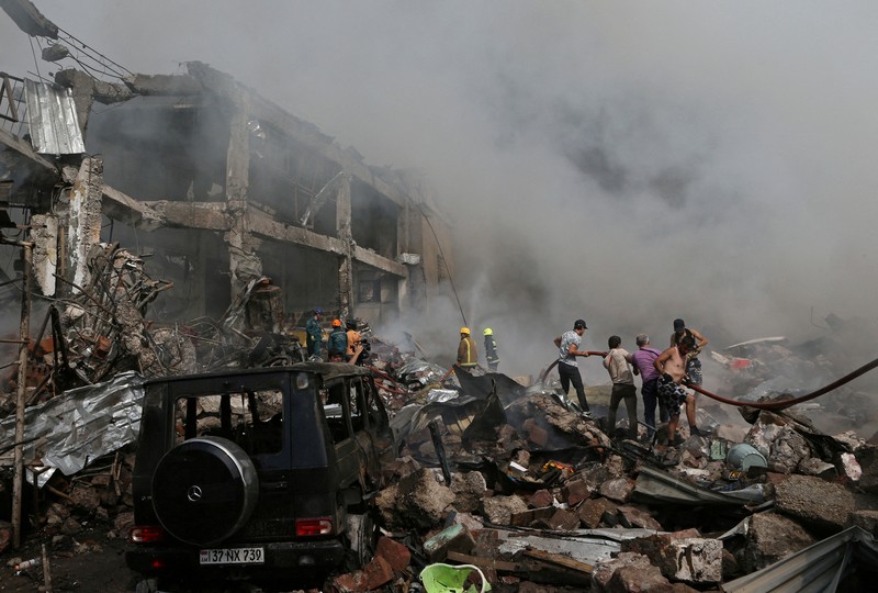 Petugas pemadam kebakaran memadamkan api setelah terjadi ledakan pada gudang kembang api di sebuah pusat perbelanjaan di Yerevan, Armenia, MInggu (14/8/2022). (Vahram Baghdasaryan/Photolure via REUTERS)