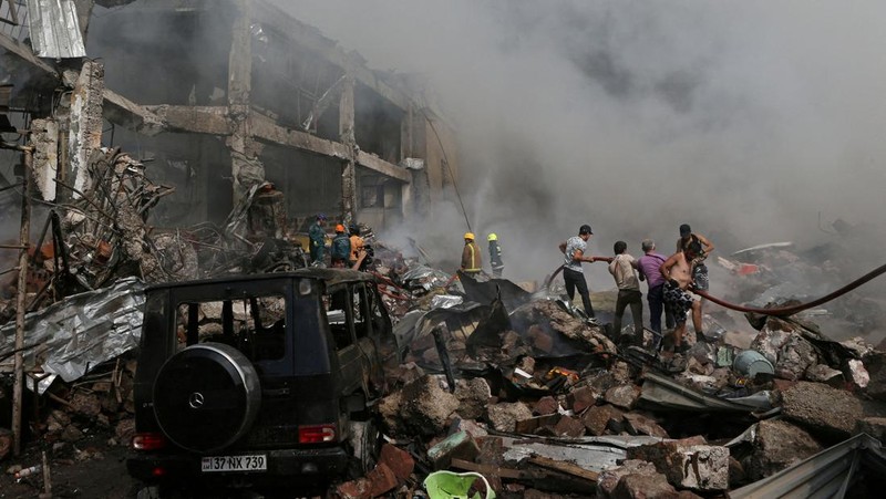Petugas pemadam kebakaran memadamkan api setelah terjadi ledakan pada gudang kembang api di sebuah pusat perbelanjaan di Yerevan, Armenia, MInggu (14/8/2022). (Vahram Baghdasaryan/Photolure via REUTERS)