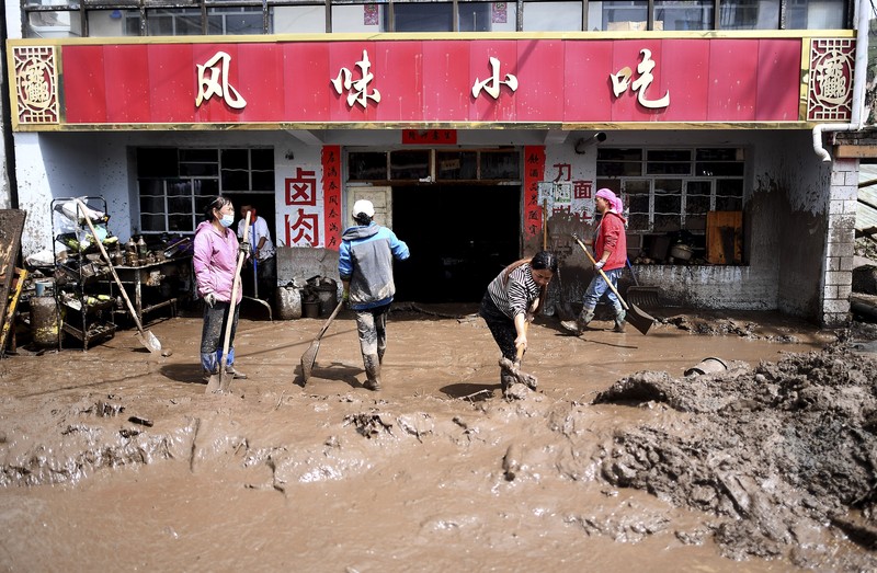 Hujan dan Banjir Bandang di China Seorang pekerja penyelamat dan anjing mencari korban setelah banjir di Desa Shadai, Kotapraja Qingshan di Datong Hui dan Kabupaten Otonom Tu di Provinsi Qinghai, Tiongkok barat laut, Kamis (18/8/2022). Badai hujan yang melanda Tiongkok barat memicu tanah longsor yang mengalihkan sungai dan menyebabkan banjir bandang di daerah berpenduduk, menewaskan beberapa orang dan membuat yang lain hilang. (Zhang Hongxiang/Xinhua via AP)