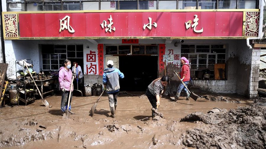 Seorang pekerja penyelamat dan anjing mencari korban setelah banjir di Desa Shadai, Kotapraja Qingshan di Datong Hui dan Kabupaten Otonom Tu di Provinsi Qinghai, Tiongkok barat laut, Kamis (18/8/2022). Badai hujan yang melanda Tiongkok barat memicu tanah longsor yang mengalihkan sungai dan menyebabkan banjir bandang di daerah berpenduduk, menewaskan beberapa orang dan membuat yang lain hilang.  (Zhang Hongxiang/Xinhua via AP)