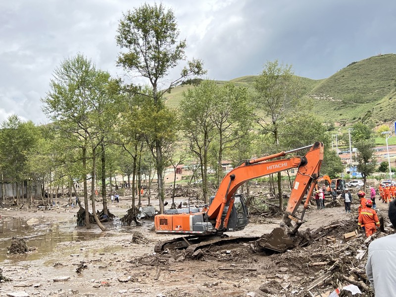Hujan dan Banjir Bandang di China Seorang pekerja penyelamat dan anjing mencari korban setelah banjir di Desa Shadai, Kotapraja Qingshan di Datong Hui dan Kabupaten Otonom Tu di Provinsi Qinghai, Tiongkok barat laut, Kamis (18/8/2022). Badai hujan yang melanda Tiongkok barat memicu tanah longsor yang mengalihkan sungai dan menyebabkan banjir bandang di daerah berpenduduk, menewaskan beberapa orang dan membuat yang lain hilang. (Zhang Hongxiang/Xinhua via AP)