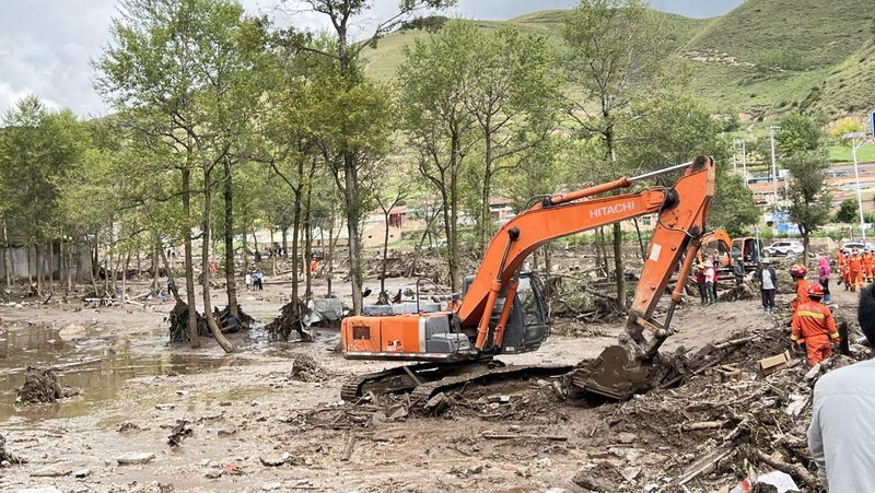Seorang pekerja penyelamat dan anjing mencari korban setelah banjir di Desa Shadai, Kotapraja Qingshan di Datong Hui dan Kabupaten Otonom Tu di Provinsi Qinghai, Tiongkok barat laut, Kamis (18/8/2022). Badai hujan yang melanda Tiongkok barat memicu tanah longsor yang mengalihkan sungai dan menyebabkan banjir bandang di daerah berpenduduk, menewaskan beberapa orang dan membuat yang lain hilang.  (Zhang Hongxiang/Xinhua via AP)