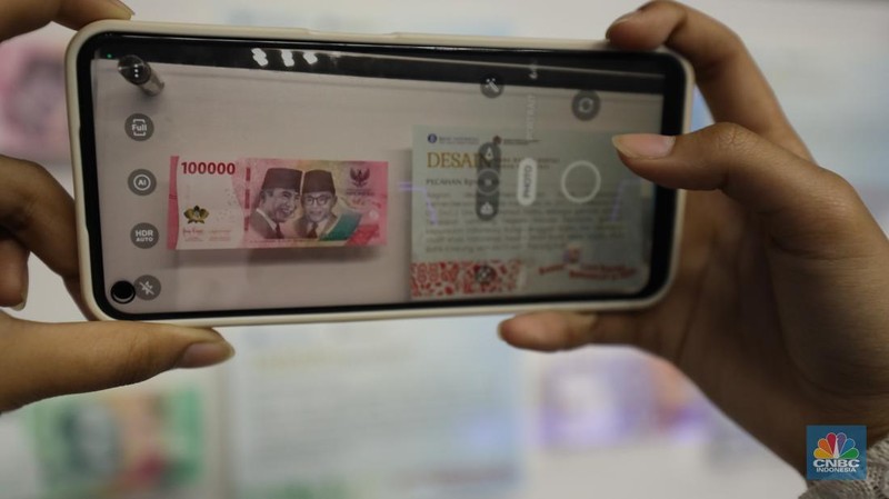 Pengunjung melihat Uang Rupiah Kertas Tahun Emisi 2022 (Uang TE 2022) dalam acara Festival Rupiah Berdaulat Bank Indonesia (FERBI) 2022 di Jakarta, Jumat (19/8/2022). (CNBC Indonesia/ Tri Susilo)