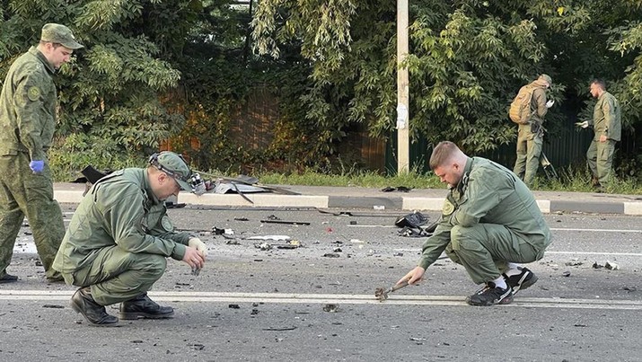 In this handout photo taken from video released by Investigative Committee of Russia on Sunday, Aug. 21, 2022, investigators work on the site of explosion of a car driven by Daria Dugina outside Moscow. Daria Dugina, the daughter of Alexander Dugin, the Russian nationalist ideologist often called 