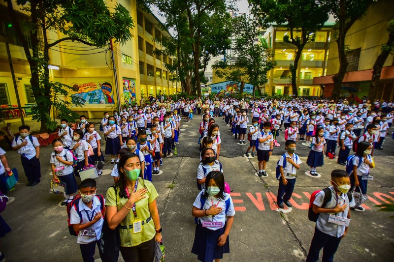 A teacher uses hand sanitizer on a student on the first day of in-person classes after years-long Covid-19 lockdowns at Pedro Guevara Elementary School in Manila on August 22, 2022. (Photo by Maria Tan / AFP) (Photo by MARIA TAN/AFP via Getty Images)