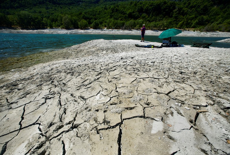 Sheep graze along the dried bed of the Guadiana river during a severe drought in the Cijara reservoir, in Villarta de los Montes, Spain, August 6, 2022.  A prolonged dry spell and extreme heat that made last July the hottest month in Spain since at least 1961, have left Spanish reservoirs at just 40% of capacity on average in early August, well below the ten-year average of around 60%, official data shows.REUTERS/Susana Vera