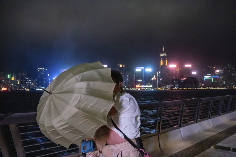In this photo released by Xinhua News Agency, a worker installs a waterproof gate at a store in Macao, China, Thursday, Aug. 24, 2022. A tropical storm was forecast to make landfall in southern China later Thursday after bringing rain and stiff winds to Hong Kong overnight as it passed to the south of the Asian financial center. (Cheong Kam Ka/Xinhua via AP)