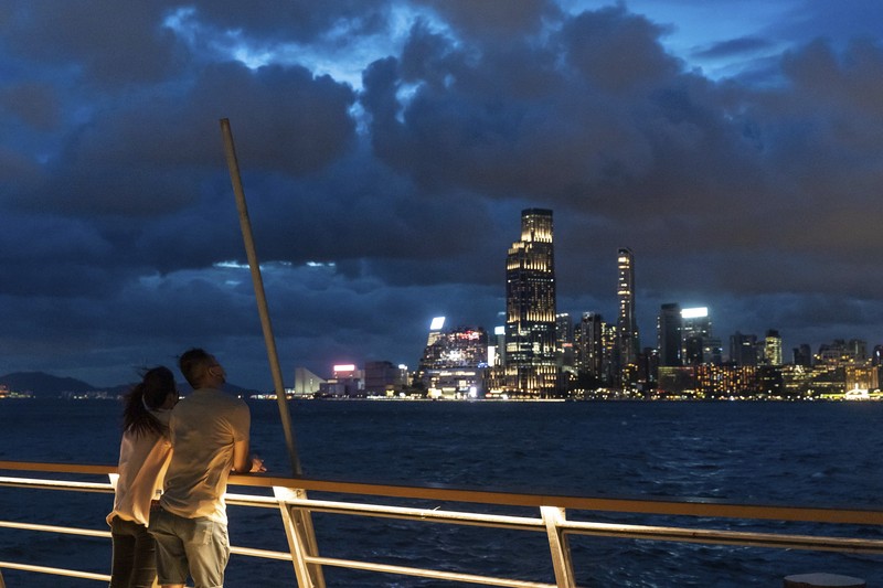 In this photo released by Xinhua News Agency, a worker installs a waterproof gate at a store in Macao, China, Thursday, Aug. 24, 2022. A tropical storm was forecast to make landfall in southern China later Thursday after bringing rain and stiff winds to Hong Kong overnight as it passed to the south of the Asian financial center. (Cheong Kam Ka/Xinhua via AP)