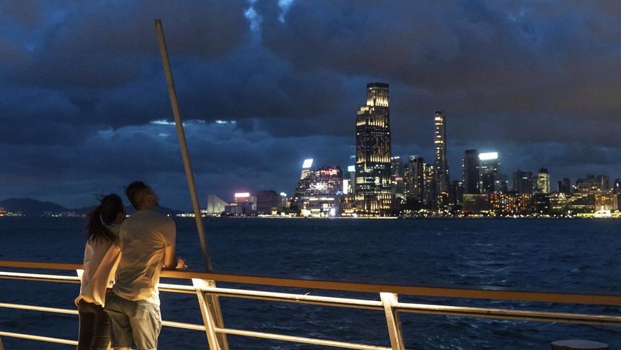 In this photo released by Xinhua News Agency, a worker installs a waterproof gate at a store in Macao, China, Thursday, Aug. 24, 2022. A tropical storm was forecast to make landfall in southern China later Thursday after bringing rain and stiff winds to Hong Kong overnight as it passed to the south of the Asian financial center. (Cheong Kam Ka/Xinhua via AP)