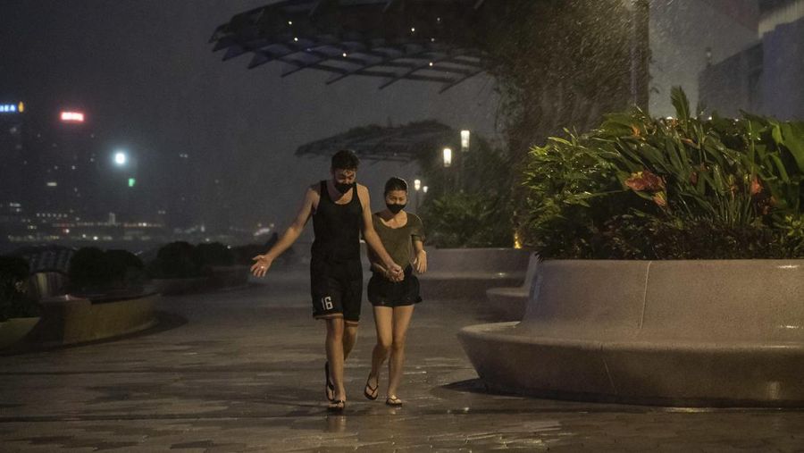 In this photo released by Xinhua News Agency, a worker installs a waterproof gate at a store in Macao, China, Thursday, Aug. 24, 2022. A tropical storm was forecast to make landfall in southern China later Thursday after bringing rain and stiff winds to Hong Kong overnight as it passed to the south of the Asian financial center. (Cheong Kam Ka/Xinhua via AP)