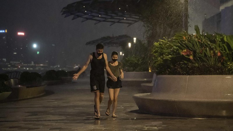 In this photo released by Xinhua News Agency, a worker installs a waterproof gate at a store in Macao, China, Thursday, Aug. 24, 2022. A tropical storm was forecast to make landfall in southern China later Thursday after bringing rain and stiff winds to Hong Kong overnight as it passed to the south of the Asian financial center. (Cheong Kam Ka/Xinhua via AP)