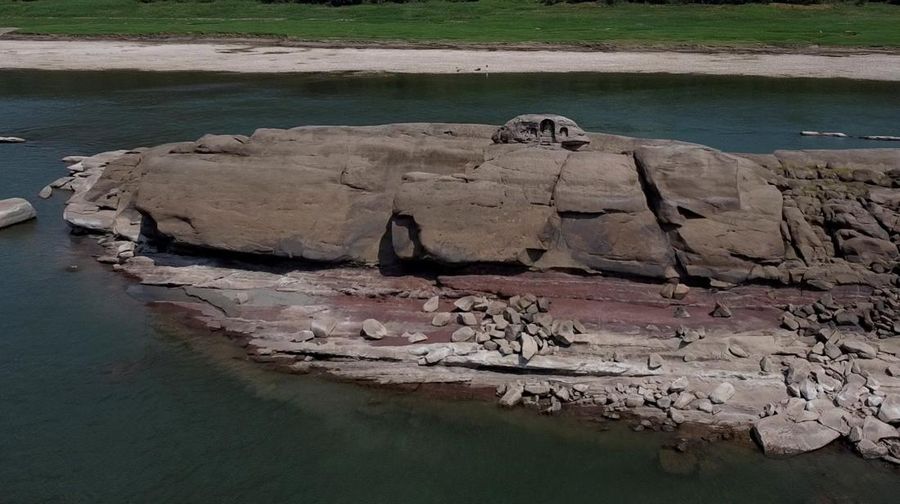 A woman in a wedding dress walks on the dried-up riverbed of the Jialing river, a tributary of the Yangtze, that is approaching record-low water levels in Chongqing, China, August 18, 2022.   REUTERS/Thomas Peter     TPX IMAGES OF THE DAY