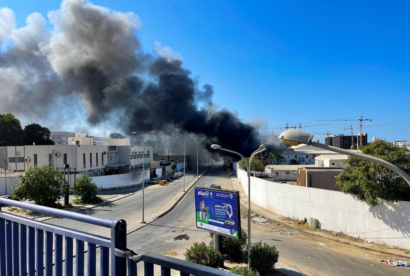 Asap mengepul setelah bentrokan antara dua milisi saingan yang beroperasi antara wilayah Qaser Ben Ghashir dan Al-Sarim, di Tripoli, Libya pada 27 Agustus 2022. (Anadolu Agency via Getty Images)