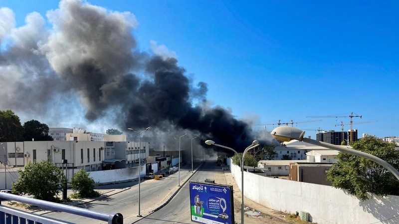 Asap mengepul setelah bentrokan antara dua milisi saingan yang beroperasi antara wilayah Qaser Ben Ghashir dan Al-Sarim, di Tripoli, Libya pada 27 Agustus 2022. (Anadolu Agency via Getty Images)