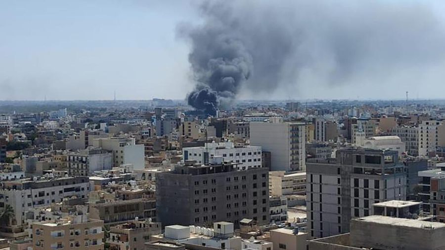 Asap mengepul setelah bentrokan antara dua milisi saingan yang beroperasi antara wilayah Qaser Ben Ghashir dan Al-Sarim, di Tripoli, Libya pada 27 Agustus 2022. (Anadolu Agency via Getty Images)