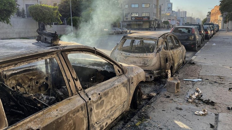 Asap mengepul setelah bentrokan antara dua milisi saingan yang beroperasi antara wilayah Qaser Ben Ghashir dan Al-Sarim, di Tripoli, Libya pada 27 Agustus 2022. (Anadolu Agency via Getty Images)