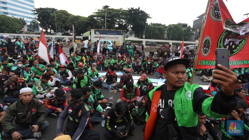 Sejumlah pengemudi ojek daring (ojol) yang tergabung dalam Koalisi Ojek Online Nasional melakukan demo di depan gedung DPR/MPR Jakarta, Senin (29/8/2022). (CNBC Indonesia/Andrean Kristianto)