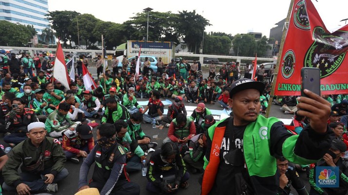 Sejumlah pengemudi ojek daring (ojol) yang tergabung dalam Koalisi Ojek Online Nasional melakukan demo di depan gedung DPR/MPR Jakarta, Senin (29/8/2022). (CNBC Indonesia/Andrean Kristianto)