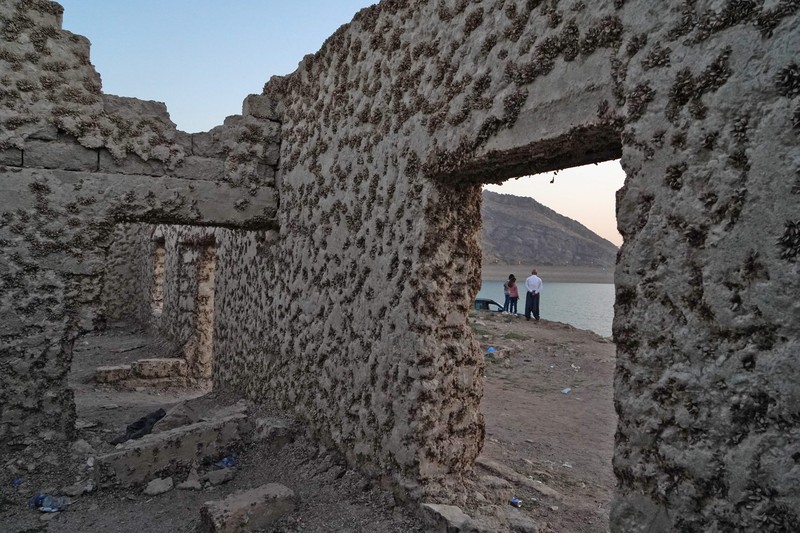 Foto udara menunjukkan sisa-sisa desa Gary Qasruka yang terendam saat Bendungan Dohuk mengalami penyusutan volume air akibat kekeringan di kota Dohuk, Irak, Minggu (28/8). (AFP via Getty Images/ISMAEL ADNAN)
