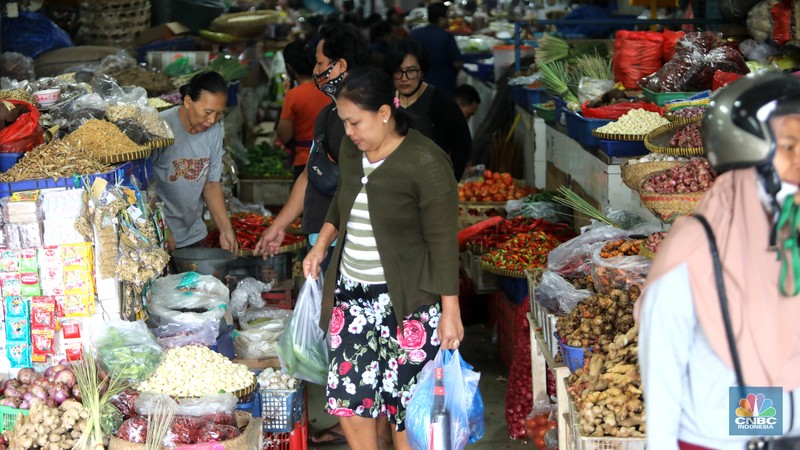 Pembeli membayar belanjaanya dengan menggunakan aplikasi pembayaran digital QRIS (QR Code Indonesian Standard) untuk transaksi dagang di pasar Badung, Denpasar, Bali, Selasa, (30/8/2022). (CNBC Indonesia/Muhammad Sabki)