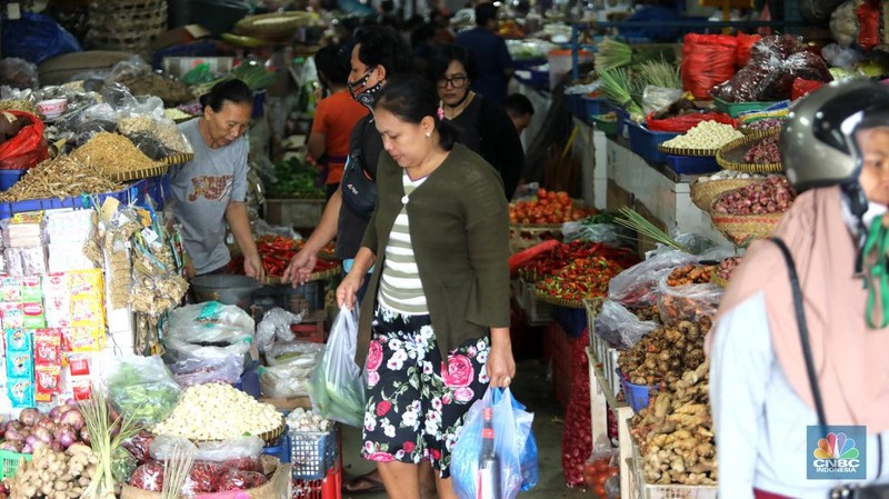 Pembeli membayar belanjaanya dengan menggunakan aplikasi pembayaran digital QRIS (QR Code Indonesian Standard) untuk transaksi dagang di pasar Badung, Denpasar, Bali, Selasa, (30/8/2022). (CNBC Indonesia/Muhammad Sabki)