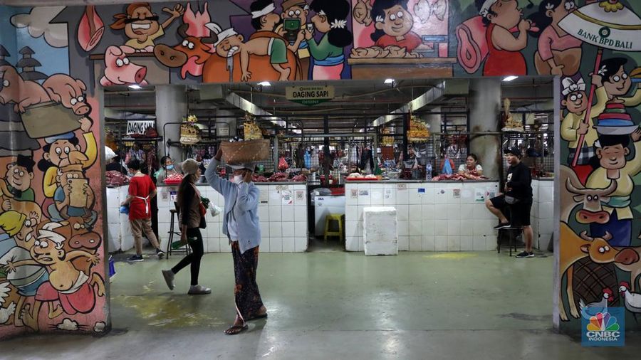 Pembeli membayar belanjaanya dengan menggunakan aplikasi pembayaran digital QRIS (QR Code Indonesian Standard) untuk transaksi dagang di pasar Badung, Denpasar, Bali, Selasa, (30/8/2022). (CNBC Indonesia/Muhammad Sabki)