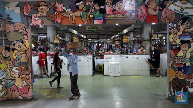 Pembeli membayar belanjaanya dengan menggunakan aplikasi pembayaran digital QRIS (QR Code Indonesian Standard) untuk transaksi dagang di pasar Badung, Denpasar, Bali, Selasa, (30/8/2022). (CNBC Indonesia/Muhammad Sabki)