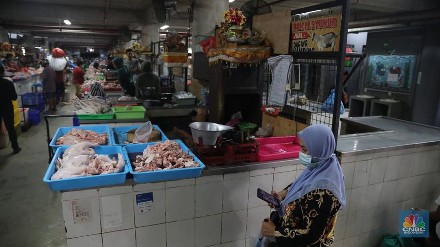 Pembeli membayar belanjaanya dengan menggunakan aplikasi pembayaran digital QRIS (QR Code Indonesian Standard) untuk transaksi dagang di pasar Badung, Denpasar, Bali, Selasa, (30/8/2022). (CNBC Indonesia/Muhammad Sabki)