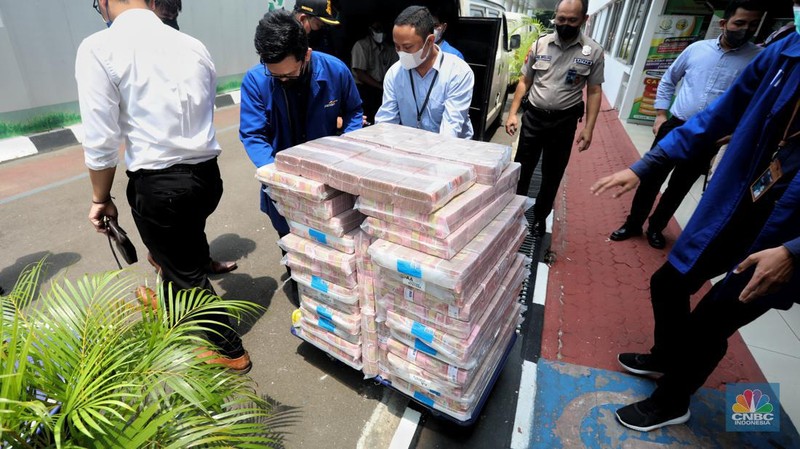Petugas merapikan uang hasil korupsi PT Dulta Palma Group di Kejaksaan Agung, Jakarta, Selasa (30/8/2022). Rincian uang tunai yang disita adalah sebesar Rp 5,12 triliun. Selain itu, ada uang tunai yang disita sebesar US$ 11,4 juta dolar Amerika Serikat (AS) atau setara sekitar Rp 168,72 miliar jika menggunakan asumsi kurs Rp 14.800 per dolar AS. (CNBC Indonesia/Andrean Kristianto)