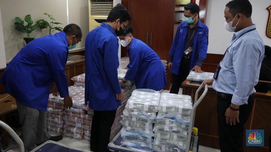Petugas merapikan uang hasil korupsi PT Dulta Palma Group di Kejaksaan Agung, Jakarta, Selasa (30/8/2022). Rincian uang tunai yang disita adalah sebesar Rp 5,12 triliun. Selain itu, ada uang tunai yang disita sebesar US$ 11,4 juta dolar Amerika Serikat (AS) atau setara sekitar Rp 168,72 miliar jika menggunakan asumsi kurs Rp 14.800 per dolar AS. (CNBC Indonesia/Andrean Kristianto)