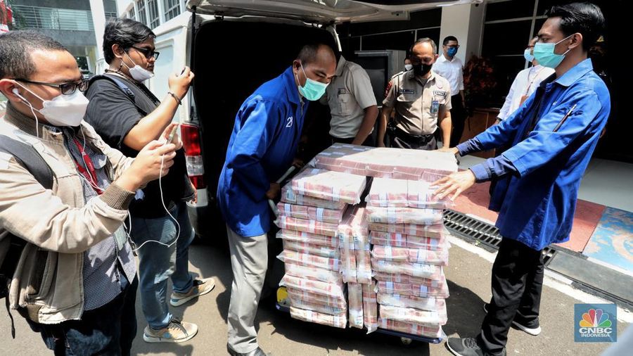 Petugas merapikan uang hasil korupsi PT Dulta Palma Group di Kejaksaan Agung, Jakarta, Selasa (30/8/2022). Rincian uang tunai yang disita adalah sebesar Rp 5,12 triliun. Selain itu, ada uang tunai yang disita sebesar US$ 11,4 juta dolar Amerika Serikat (AS) atau setara sekitar Rp 168,72 miliar jika menggunakan asumsi kurs Rp 14.800 per dolar AS. (CNBC Indonesia/Andrean Kristianto)