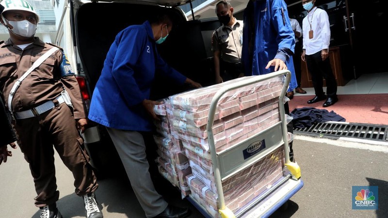 Petugas merapikan uang hasil korupsi PT Dulta Palma Group di Kejaksaan Agung, Jakarta, Selasa (30/8/2022). Rincian uang tunai yang disita adalah sebesar Rp 5,12 triliun. Selain itu, ada uang tunai yang disita sebesar US$ 11,4 juta dolar Amerika Serikat (AS) atau setara sekitar Rp 168,72 miliar jika menggunakan asumsi kurs Rp 14.800 per dolar AS. (CNBC Indonesia/Andrean Kristianto)