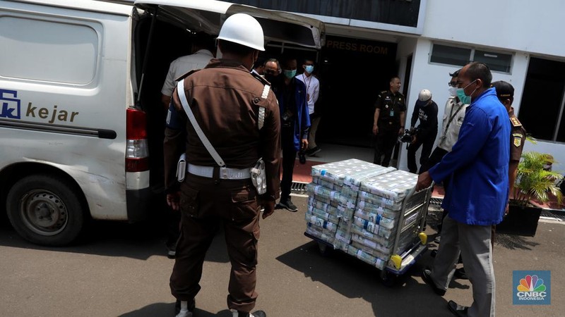 Petugas merapikan uang hasil korupsi PT Dulta Palma Group di Kejaksaan Agung, Jakarta, Selasa (30/8/2022). Rincian uang tunai yang disita adalah sebesar Rp 5,12 triliun. Selain itu, ada uang tunai yang disita sebesar US$ 11,4 juta dolar Amerika Serikat (AS) atau setara sekitar Rp 168,72 miliar jika menggunakan asumsi kurs Rp 14.800 per dolar AS. (CNBC Indonesia/Andrean Kristianto)