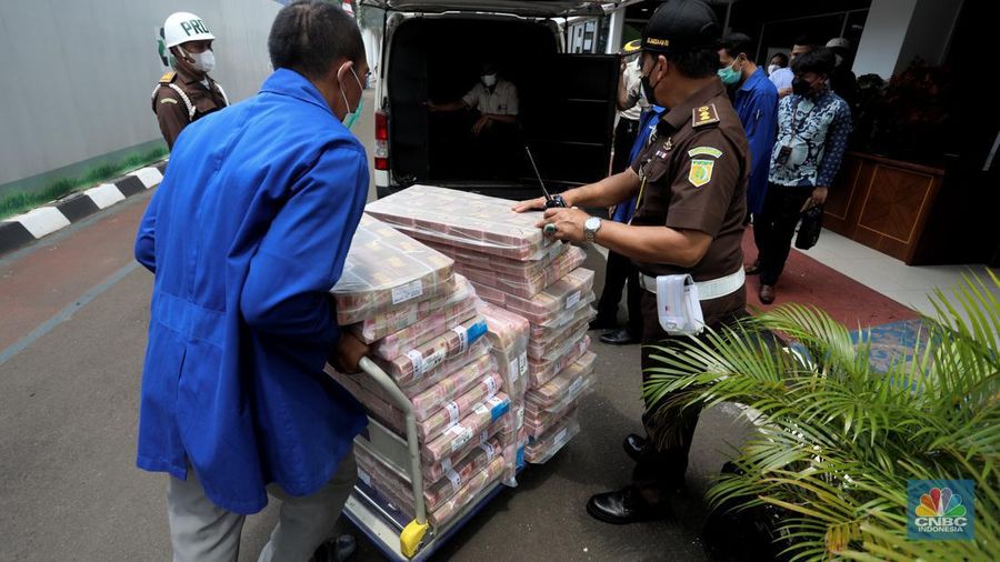 Petugas merapikan uang hasil korupsi PT Dulta Palma Group di Kejaksaan Agung, Jakarta, Selasa (30/8/2022). Rincian uang tunai yang disita adalah sebesar Rp 5,12 triliun. Selain itu, ada uang tunai yang disita sebesar US$ 11,4 juta dolar Amerika Serikat (AS) atau setara sekitar Rp 168,72 miliar jika menggunakan asumsi kurs Rp 14.800 per dolar AS. (CNBC Indonesia/Andrean Kristianto)